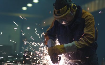 Welder in industrial setting demonstrating air circulation needs for cooling and ventilation.