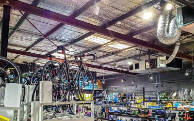 Indoor bicycle shop showcasing Airius air circulation systems, featuring high ceilings, bikes on display, and