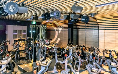 Airius cooling fans installed in a modern fitness studio with stationary bikes, showcasing advanced air