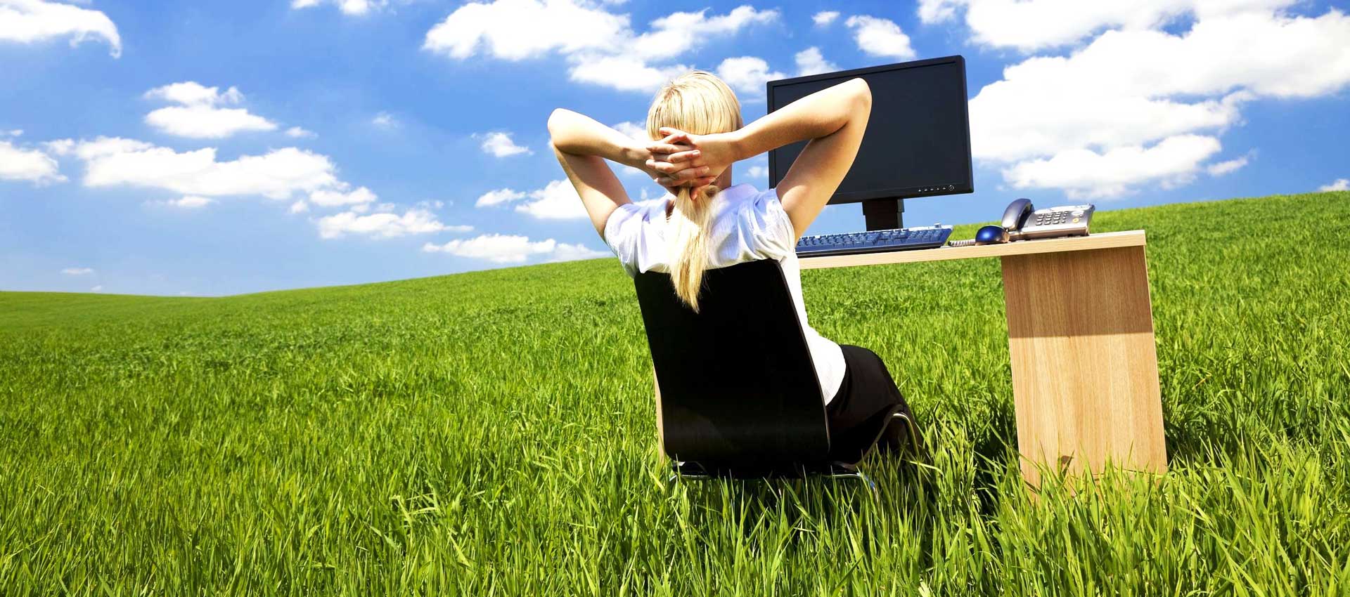 Person relaxing outdoors with desk and computer illustrating improved indoor air quality and staff well-being.