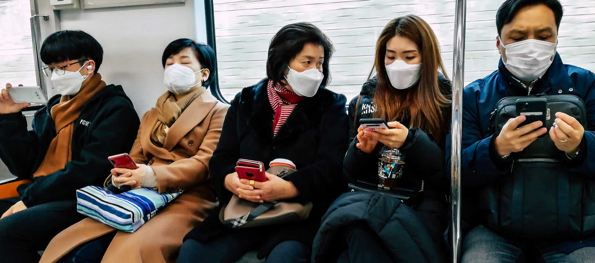 Airius-PureAir-Effective-at-Killing-Coronaviruses People wearing face masks on public transport illustrating Airius PureAir technology and COVID-19 testing.