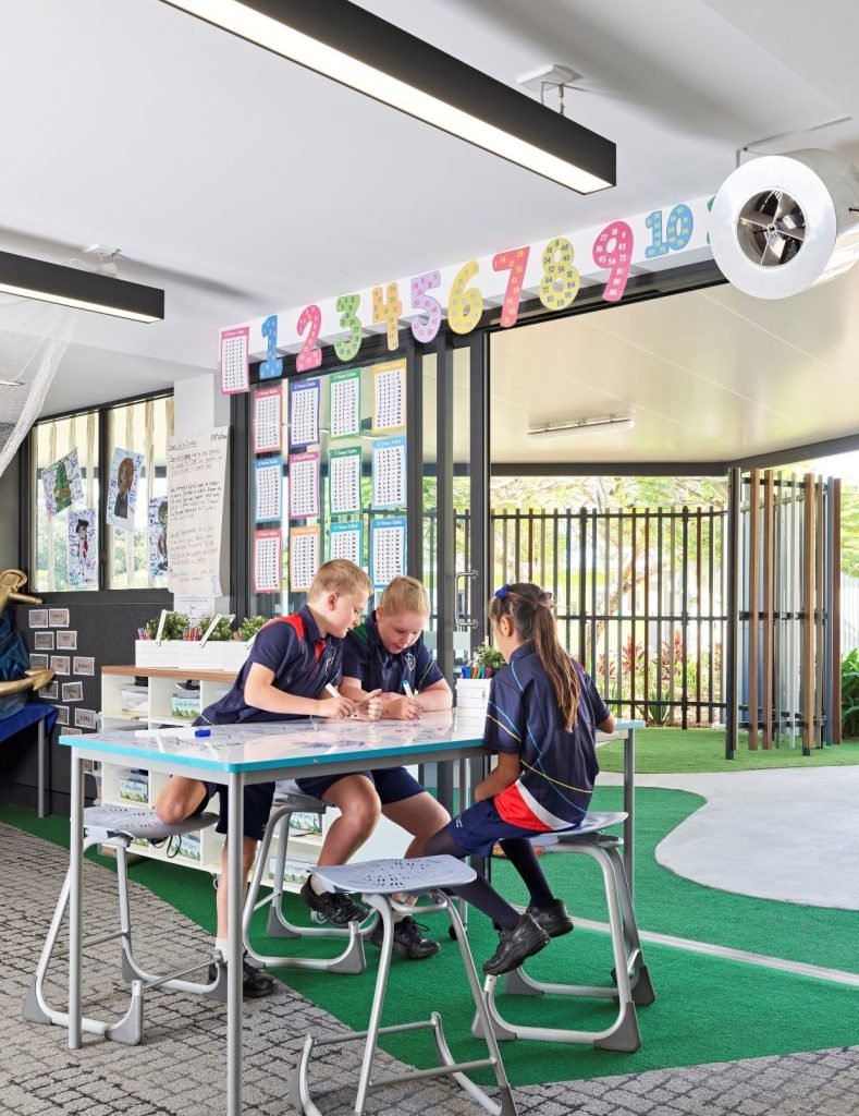 Children learning in a school classroom with Airius fans providing comfortable airflow.