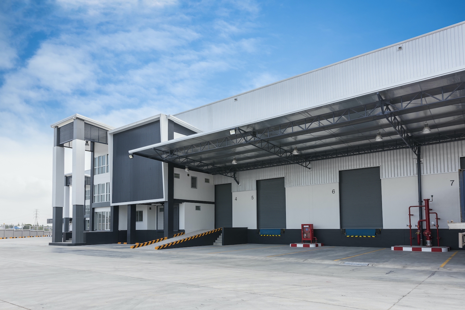 Large modern warehouse building Warehouse loading dock with semi-trailer and Airius fans for exhaust fume ventilation.