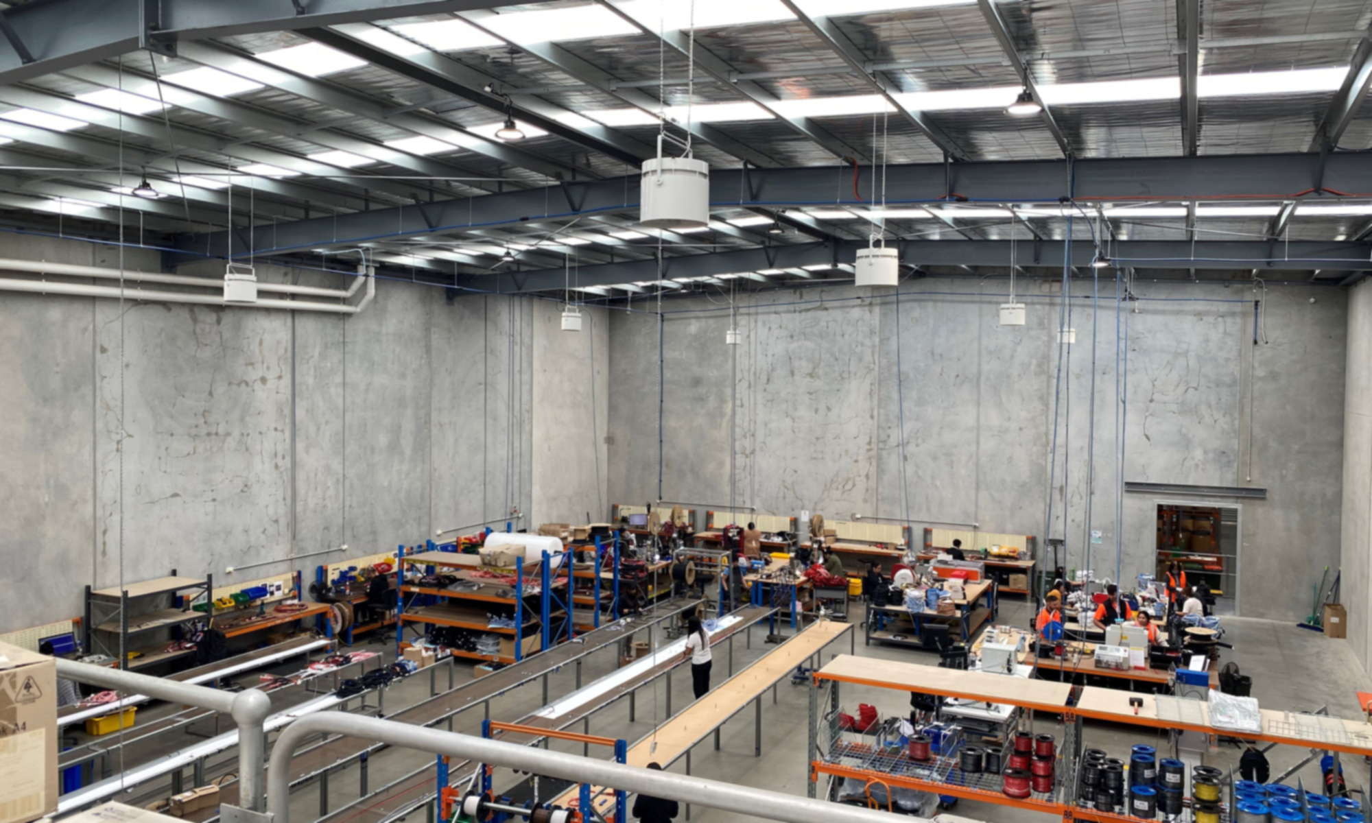 warehouse-cooling-part-one Large warehouse interior with high ceilings and Airius destratification fans improving airflow and worker comfort.