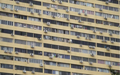 High-rise building facade with numerous air conditioning units illustrating warehouse cooling challenges.