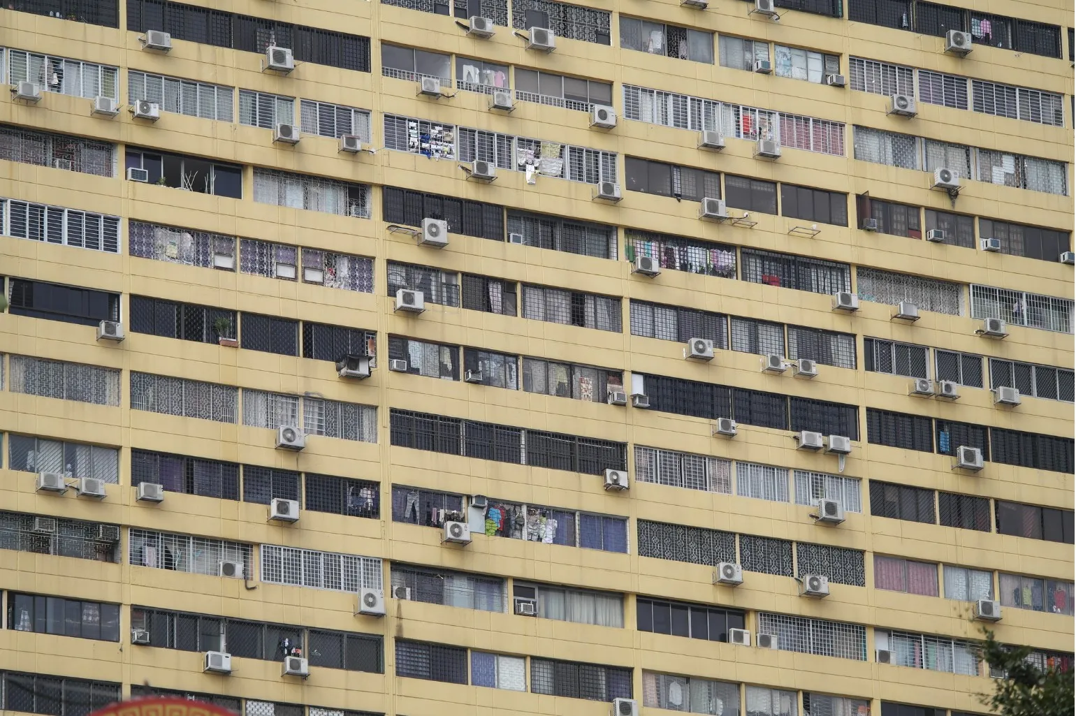 High-rise building facade with numerous air conditioning units illustrating energy savings with hybrid cooling.
