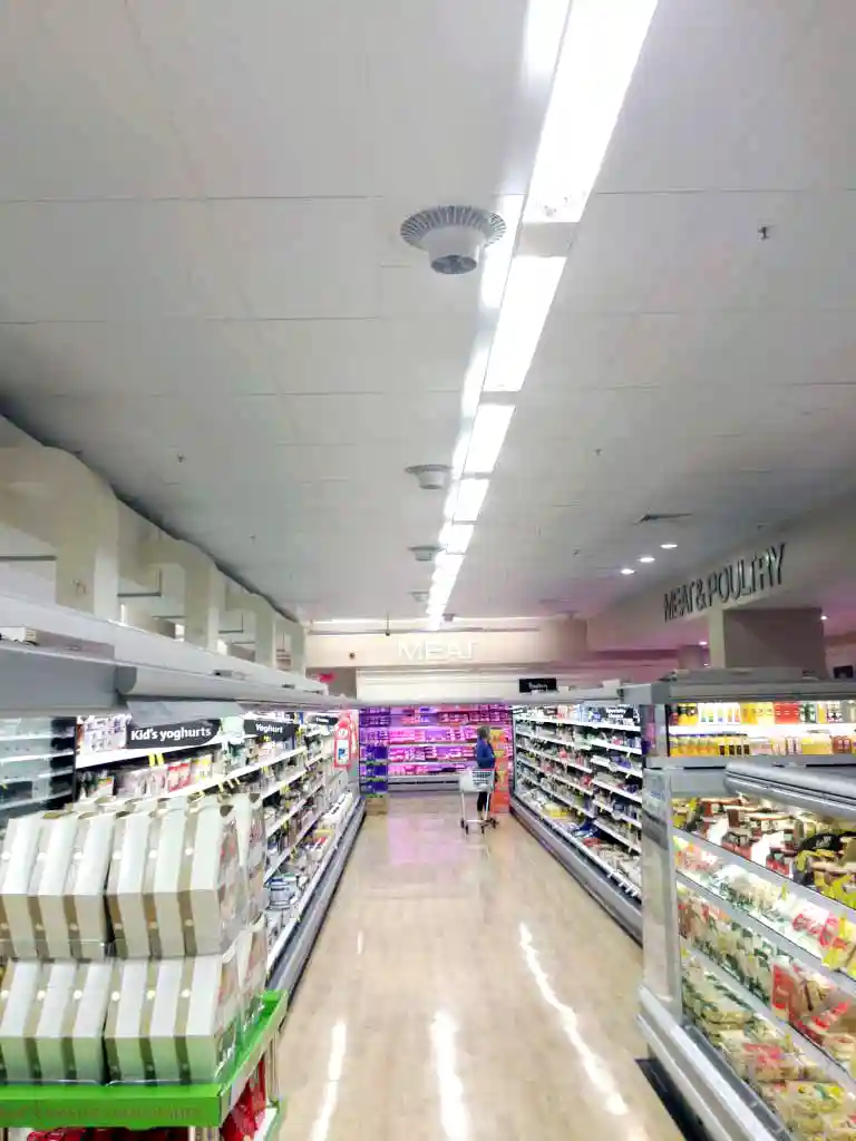 Airius cooling fan installed in supermarket aisle improving air circulation and reducing condensation.