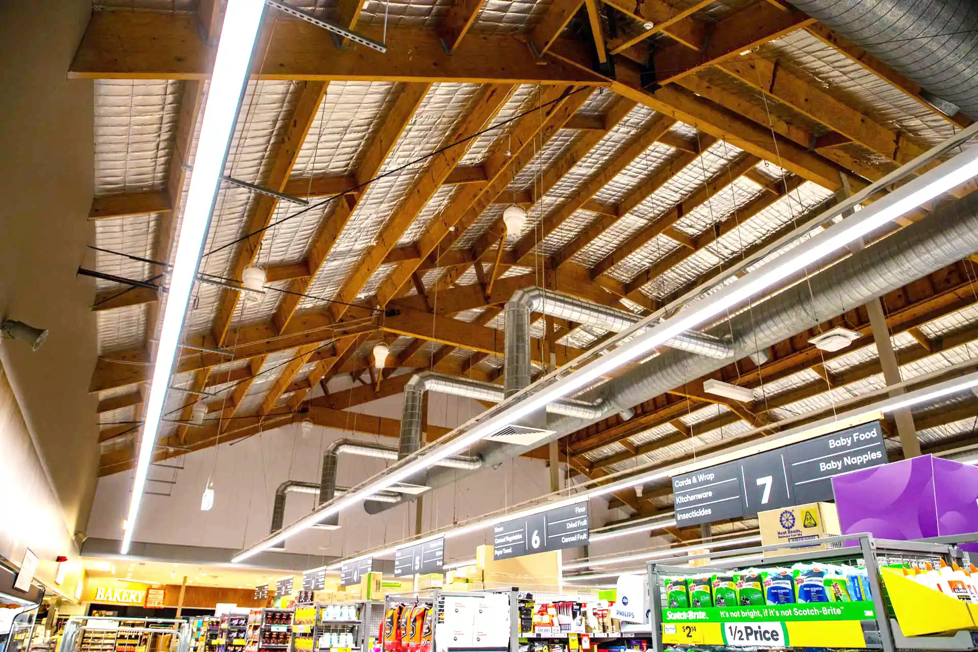 Supermarket ceiling with Airius cooling fans and ductwork improving air circulation and reducing condensation.