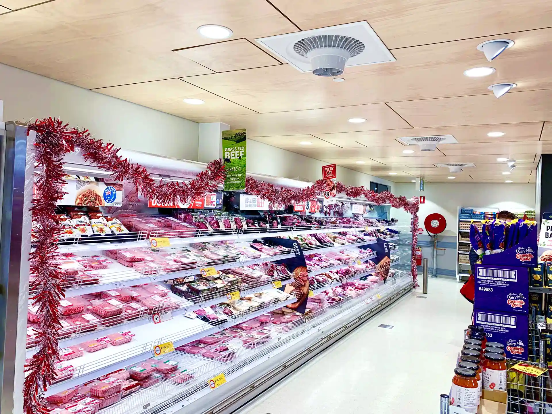 Supermarket meat display case with Airius fan improving air circulation and reducing condensation.