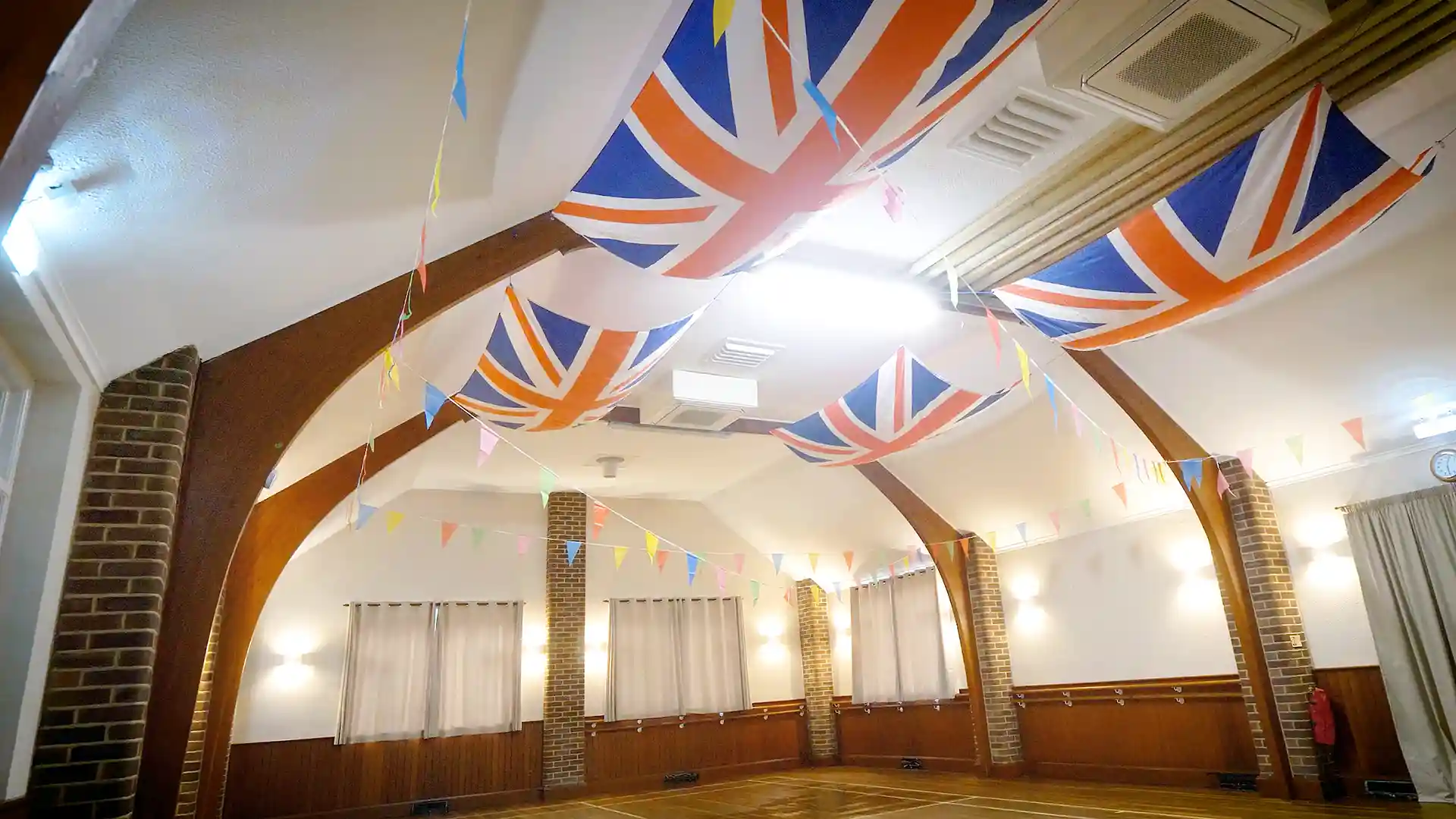Eversley Village Hall interior with Union Jack flags and bunting, showcasing improved comfort with Airius
