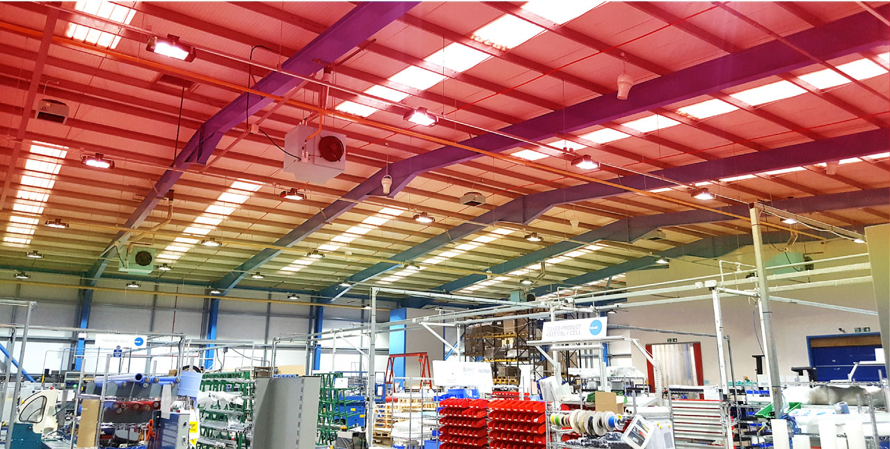 Large industrial facility ceiling with Airius destratification fans and lighting.