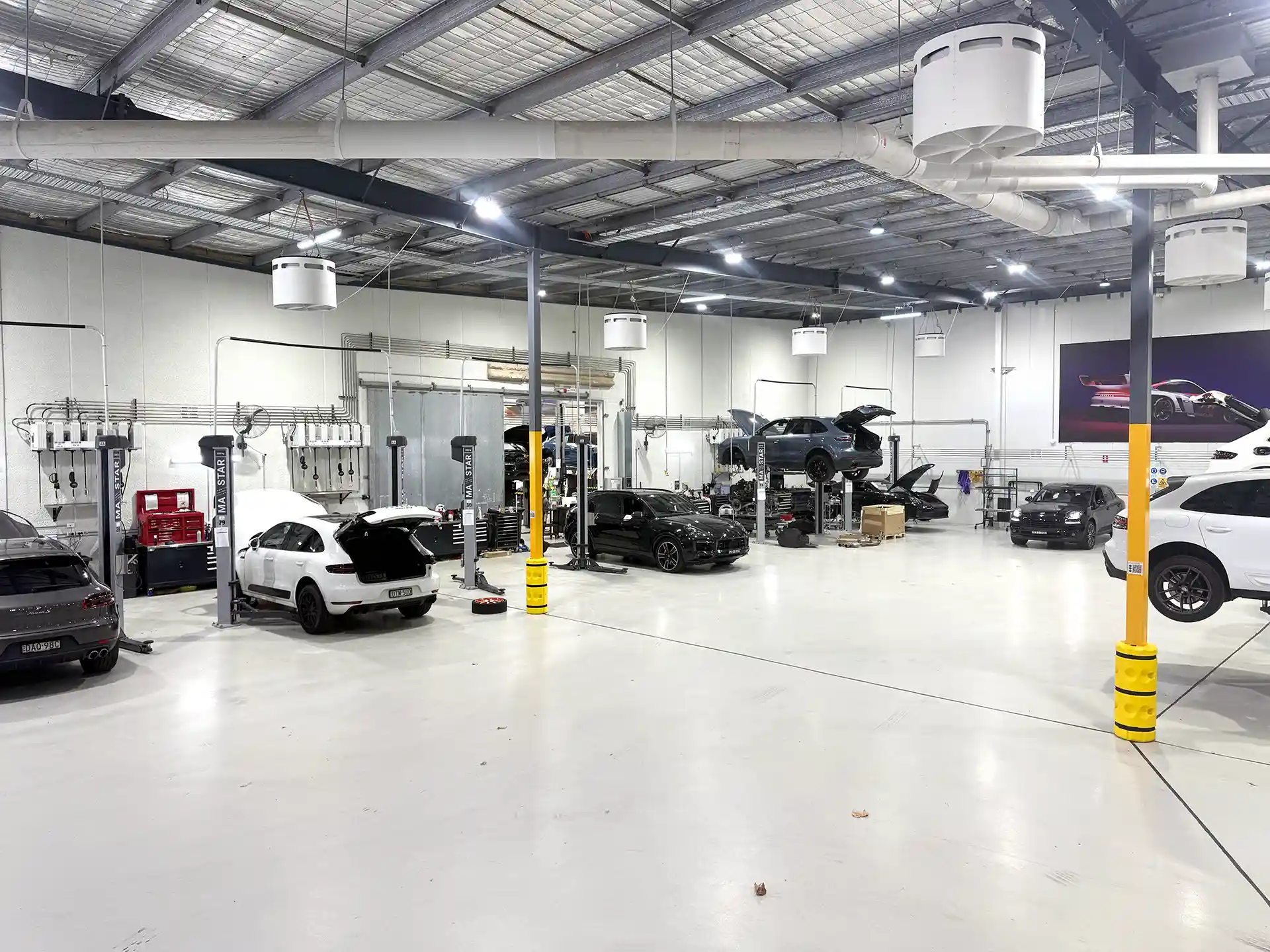 Porsche automotive workshop with Airius Emerald fan system providing airflow cooling and destratification.