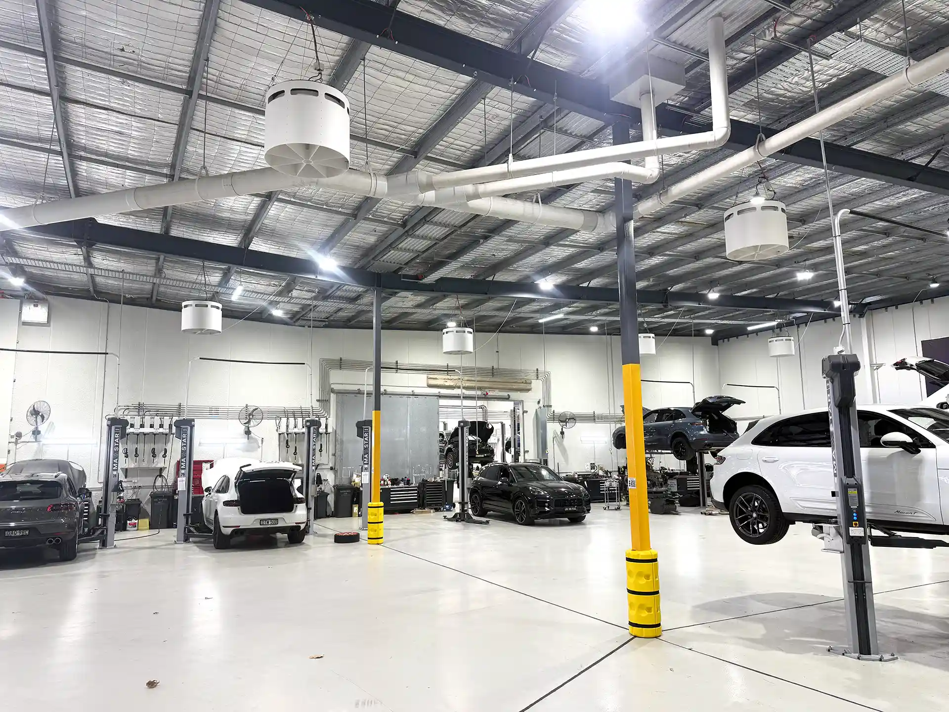 Porsche automotive workshop with Airius Emerald fans providing airflow and destratification.